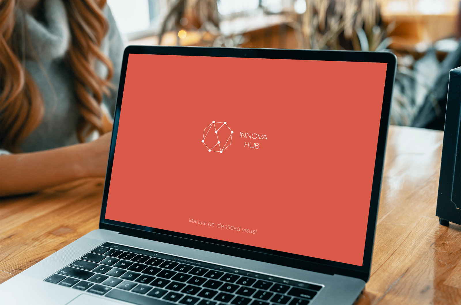 Laptop mockup displaying red cover of Innovahub brand book